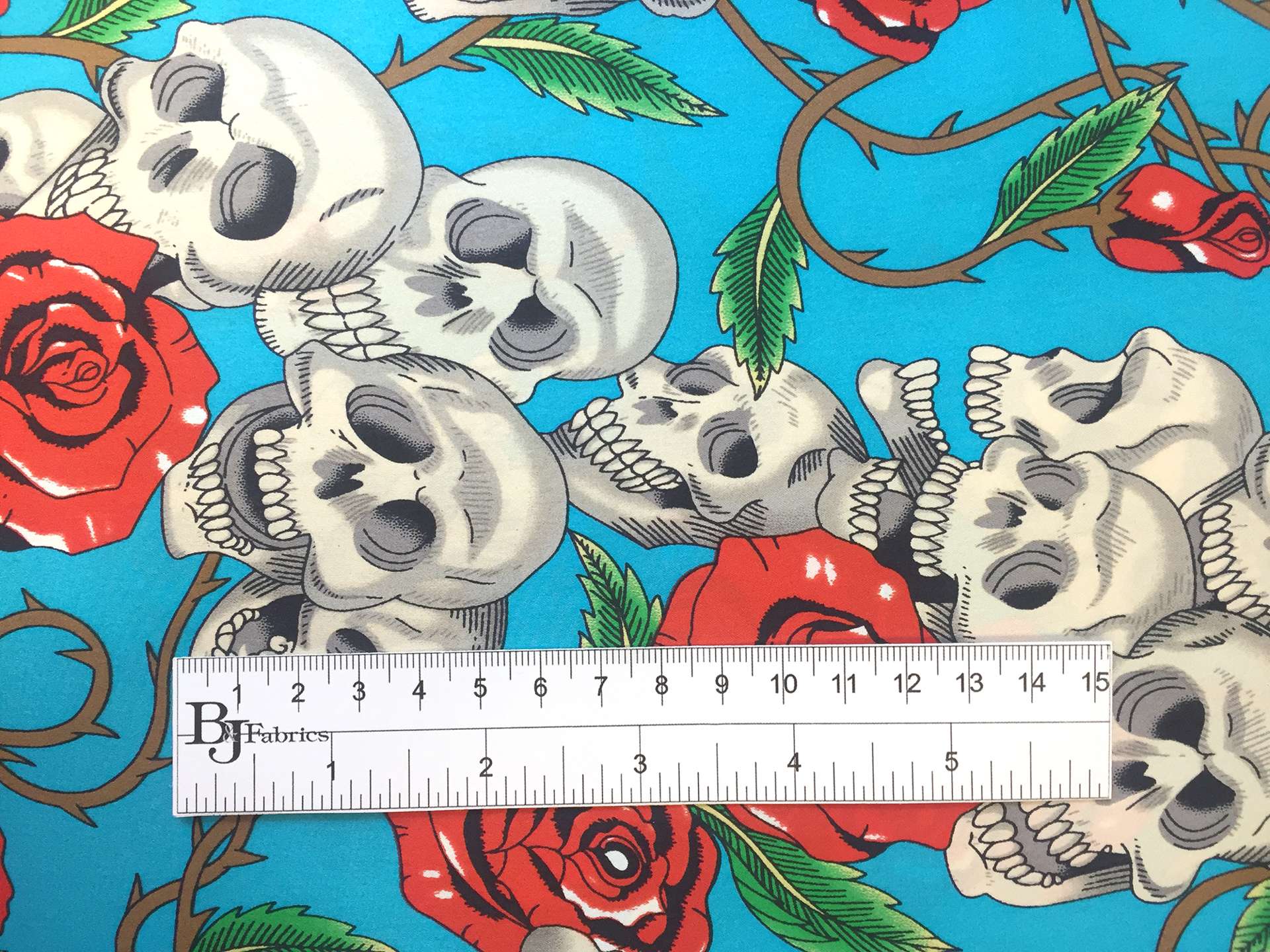 Printed Silk Charmeuse with Skulls and Roses in Blue Background
