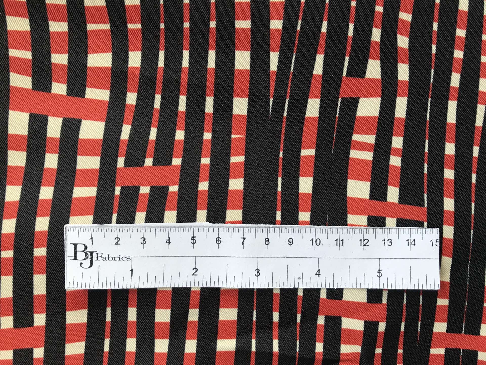 ruler sits on top of printed polyester mikado with weave-like pattern to show scale of pattern