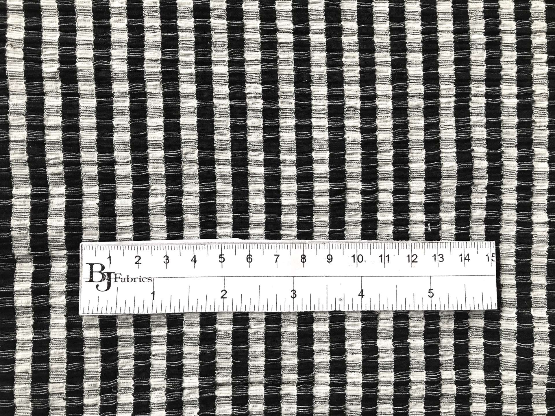 ruler sits on top of polyester popcorn knit to show scale