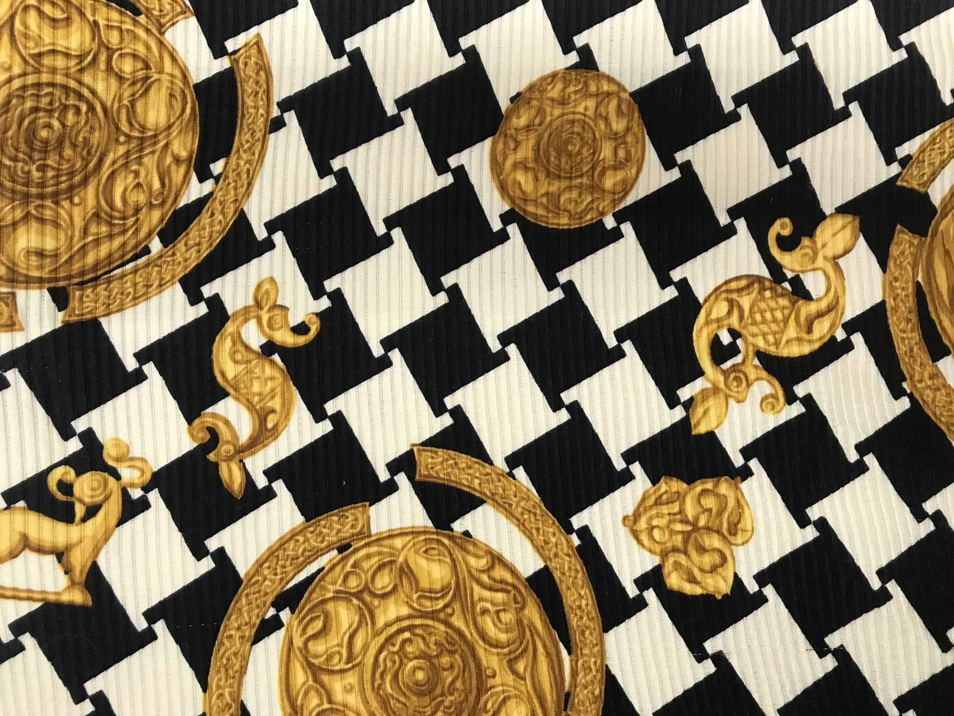 silk and wool printed ottoman, black and white abstract houndstooth and gold trinkets 