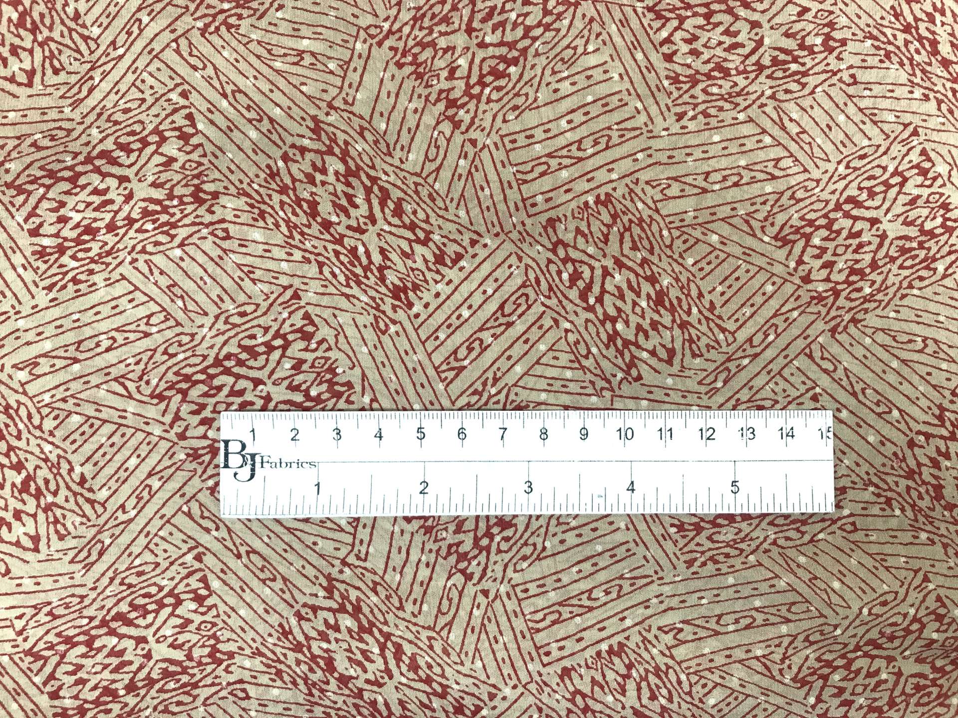 taupe printed silk chiffon with red abstract patterns with ruler to show scale
