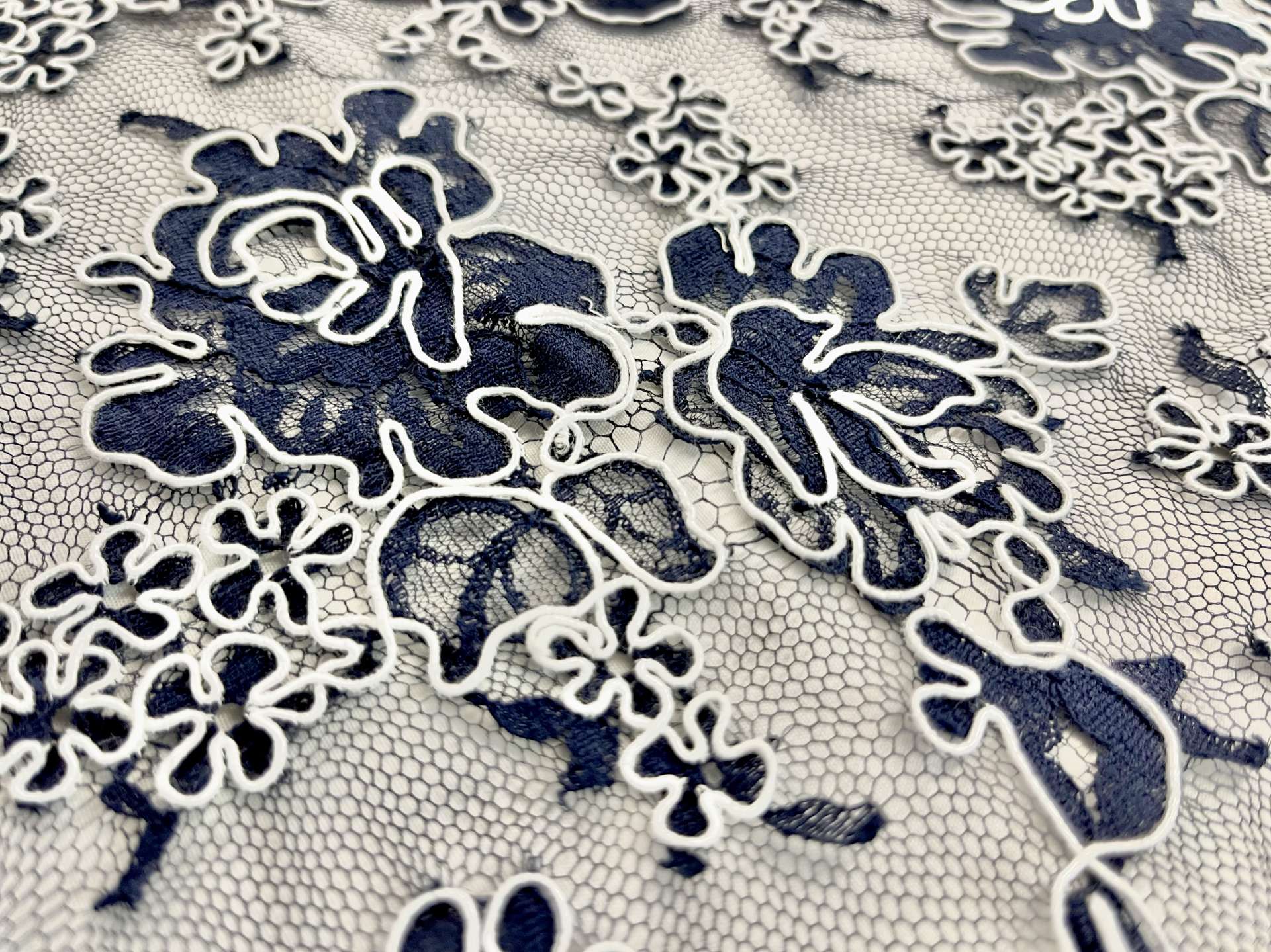 French Navy Blue Alençon Lace with Roses Outlined by White Cordings.