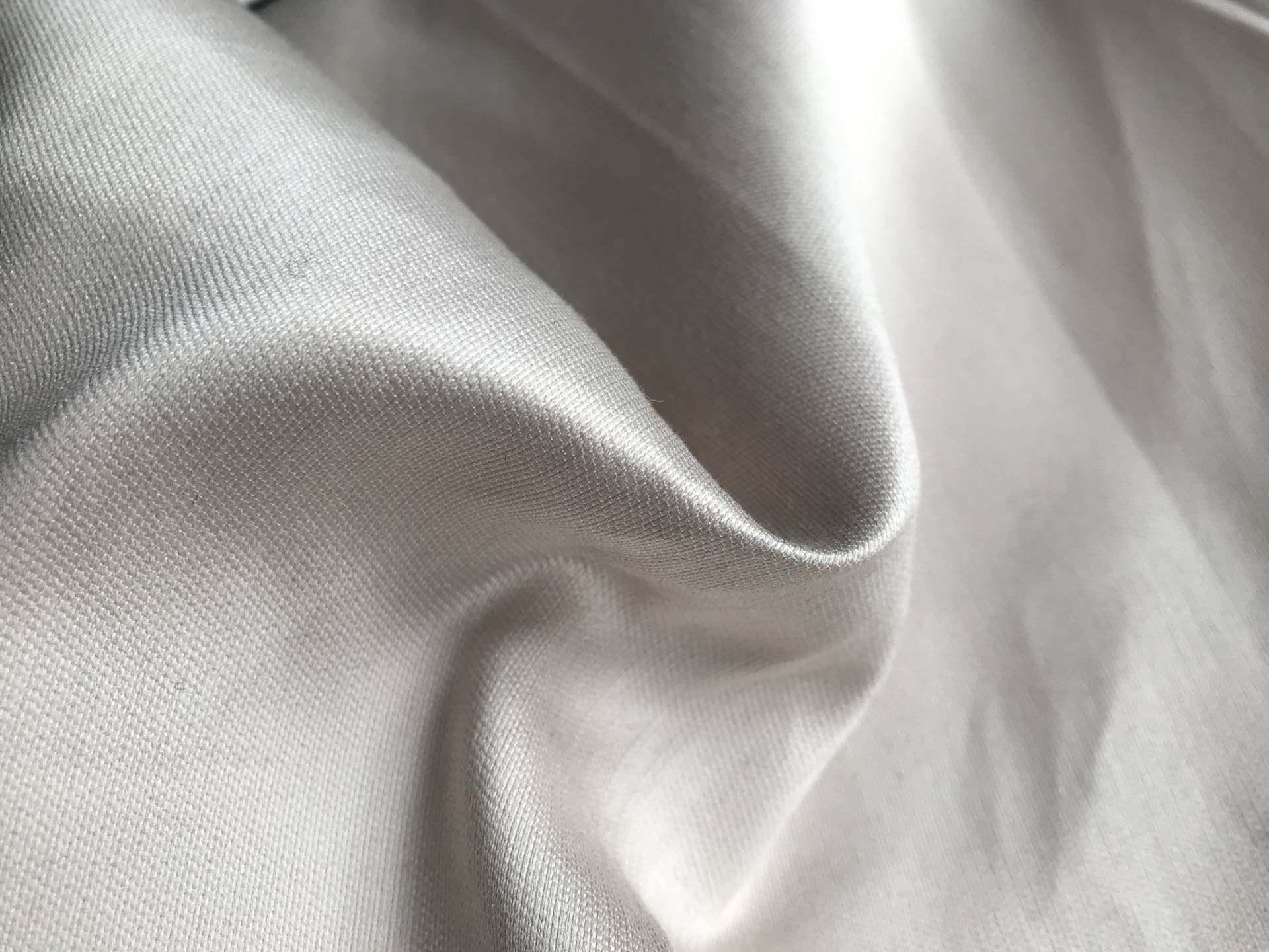 ivory satin is scrunched up to show texture and sheen