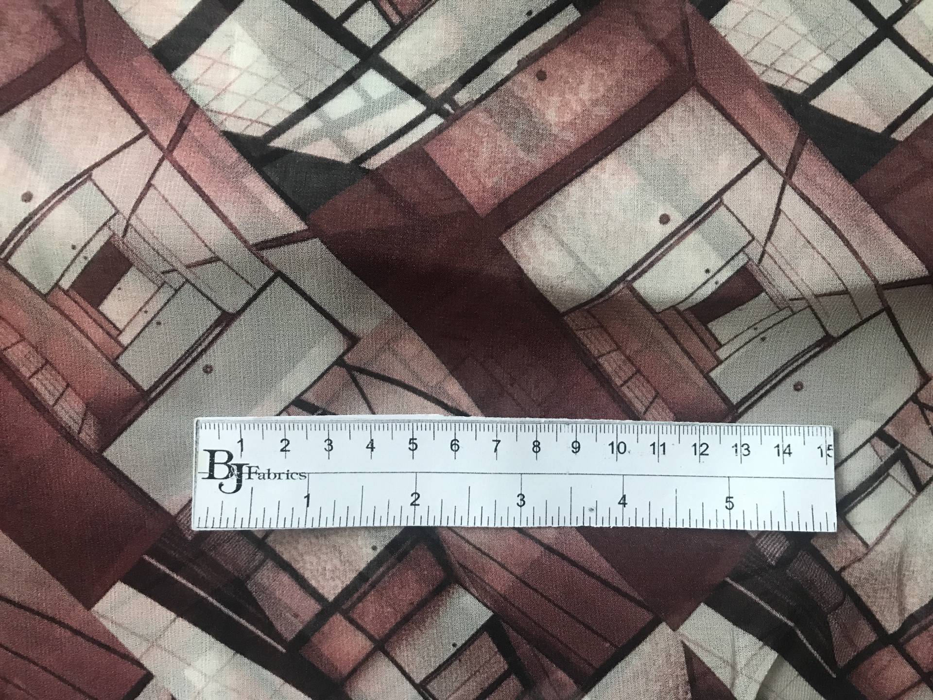 ruler sits on top of geometric printed silk chiffon to show scale of pattern