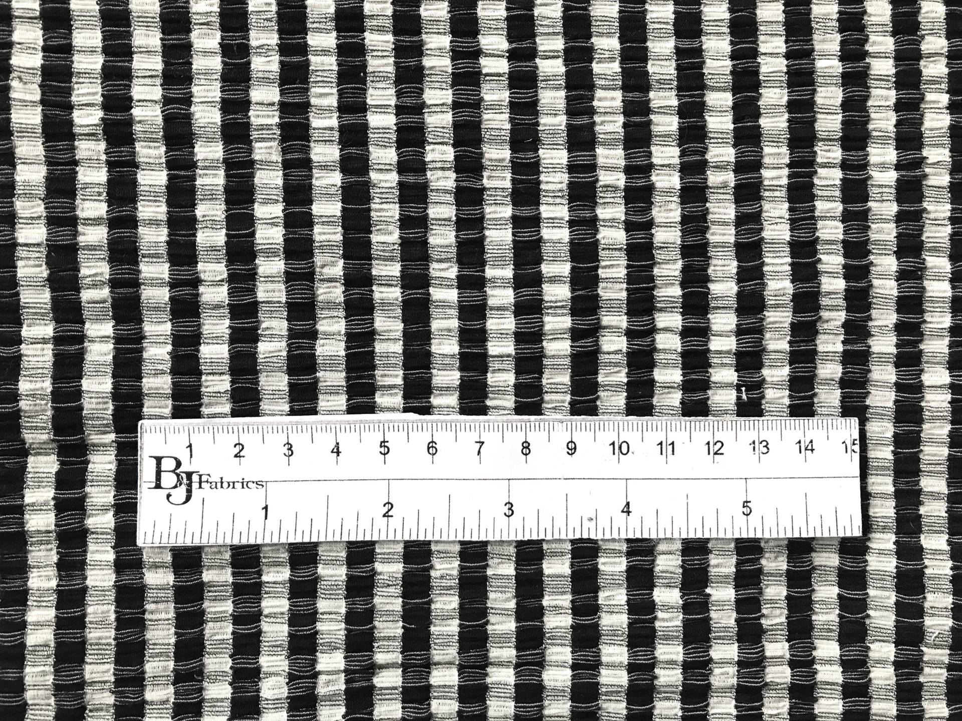 ruler sits on top of polyester popcorn knit to show scale