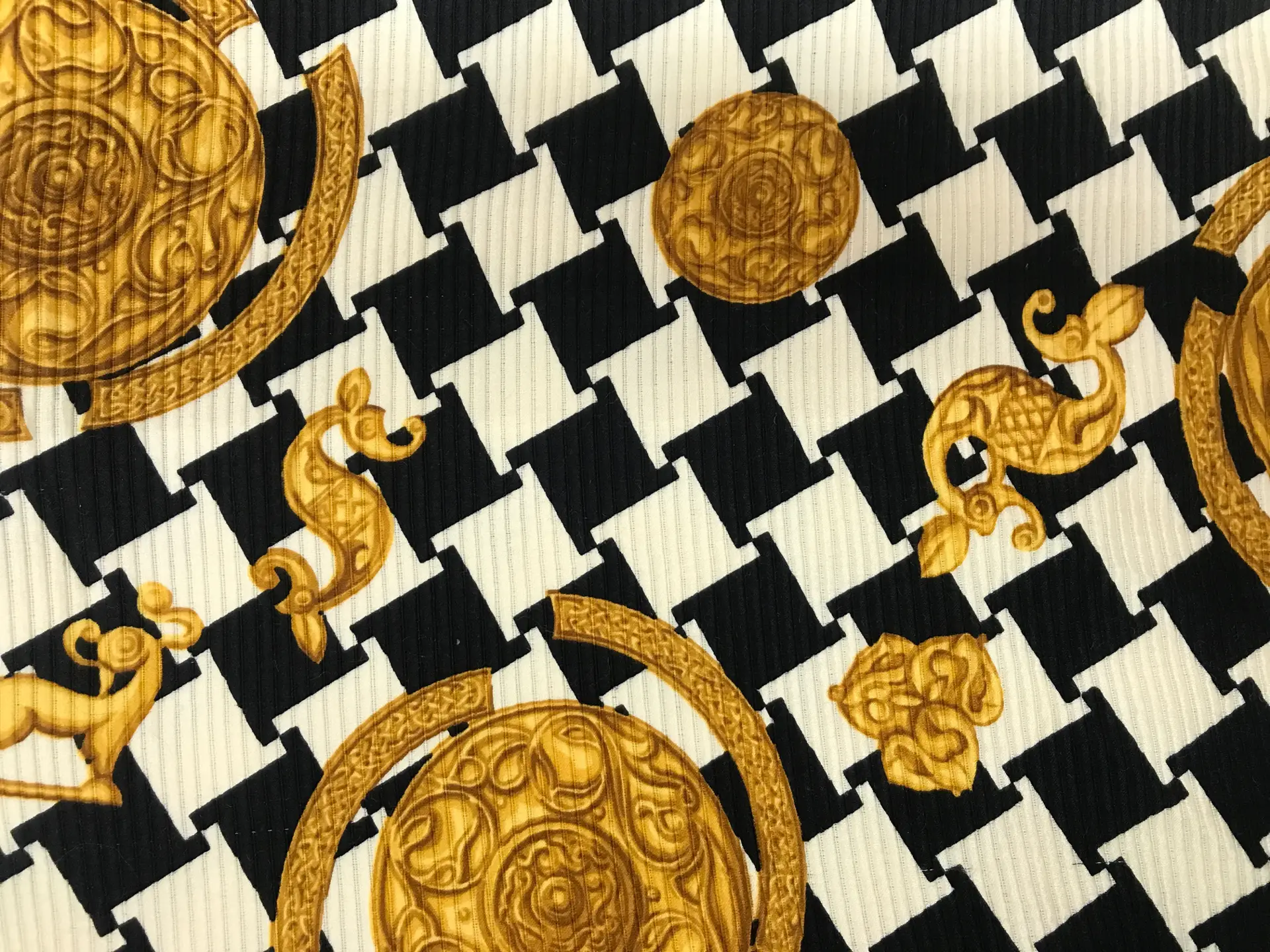 silk and wool printed ottoman, black and white abstract houndstooth and gold trinkets 