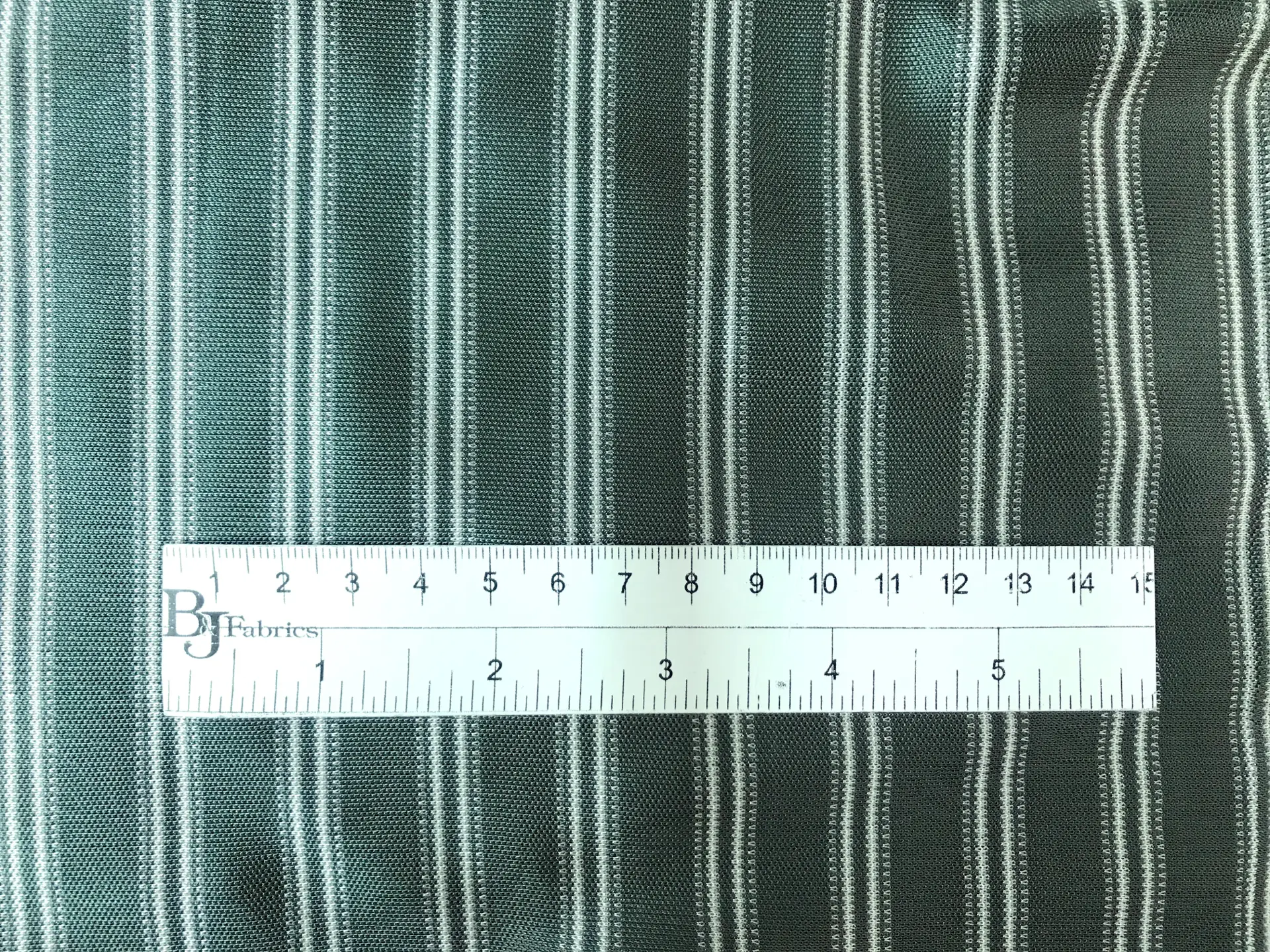 rayon jersey stripe in sage with ruler to show scale