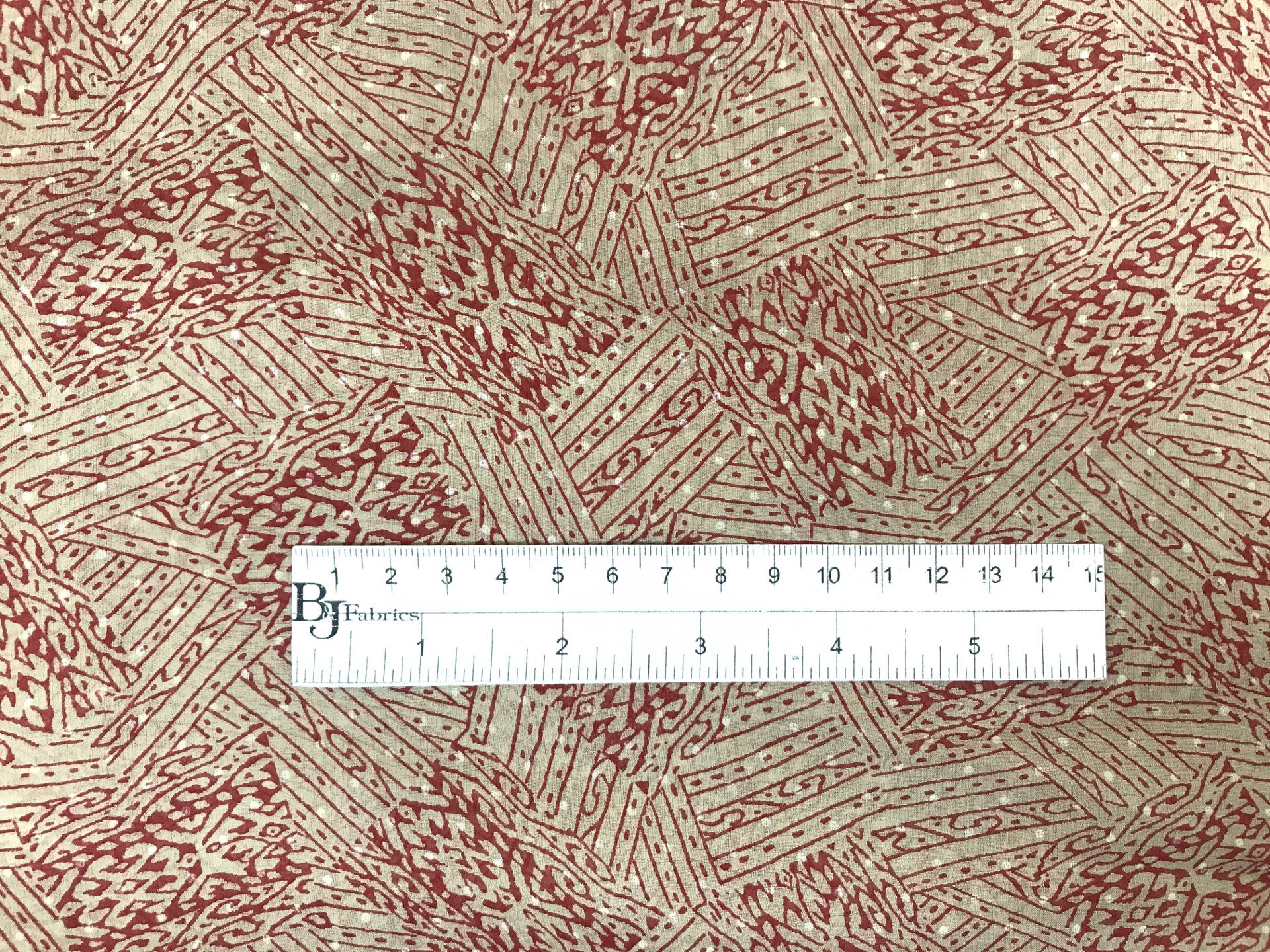 taupe printed silk chiffon with red abstract patterns with ruler to show scale